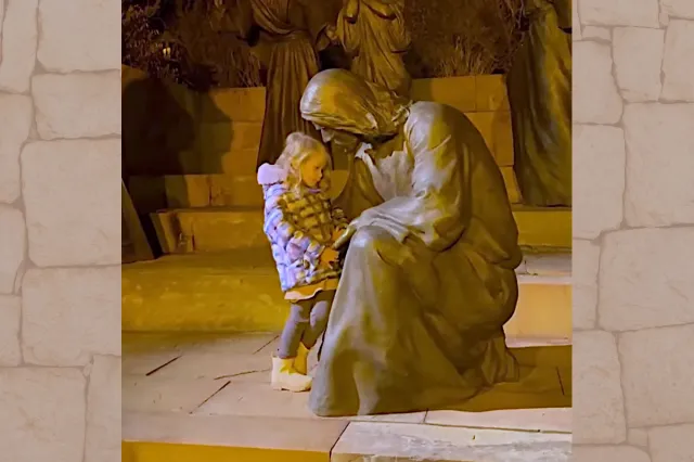 This little girl cuddling up to a statue of Jesus is simply divine!